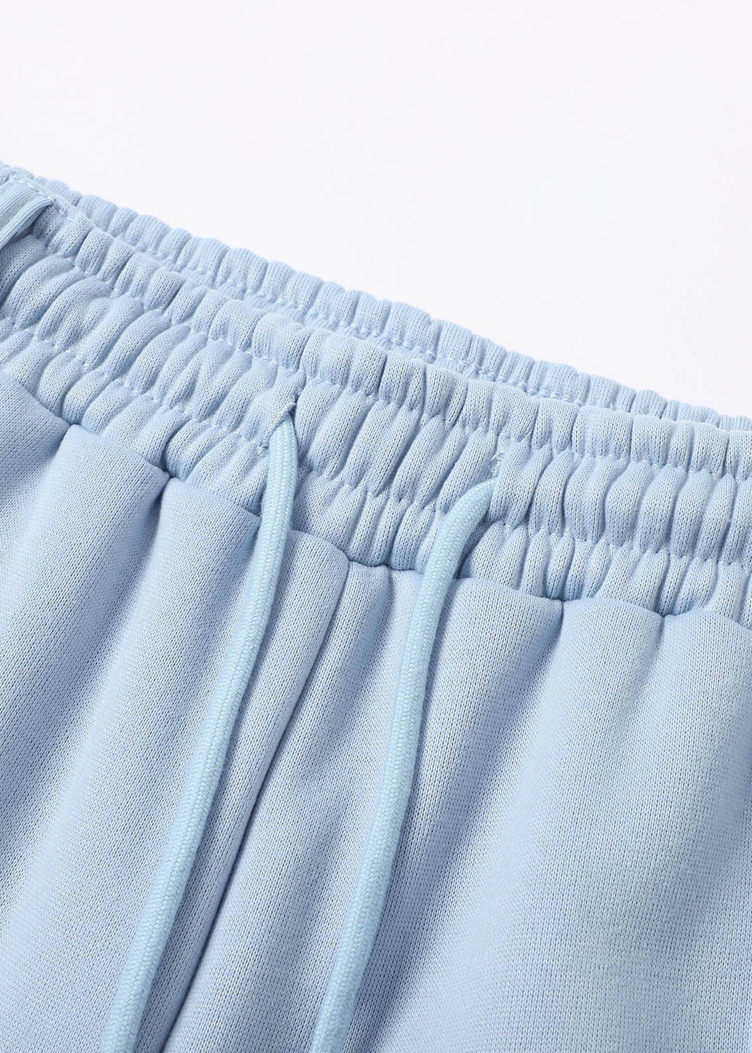 Close-up of light blue pants with an elastic waistband on a white background